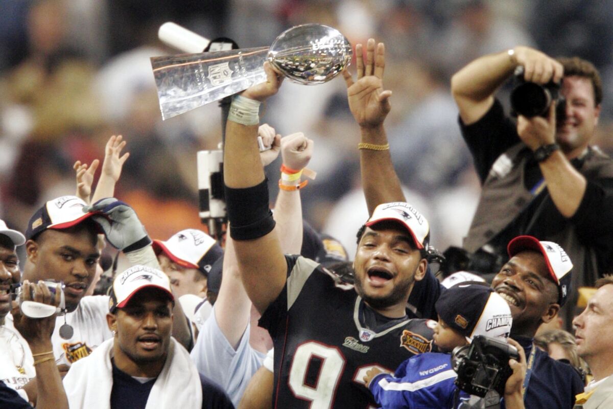 FILE - New England Patriots' Richard Seymour (93) holds the Vince Lombardi trophy after the Patriots defeated the Carolina Panthers 32-29 to win Super Bowl XXXVIII on Feb. 1, 2004, in Houston. Seymour's winning start in New England is a good starting point for how the defensive lineman ended up in the Pro Football Hall of Fame. The Patriots won the Super Bowl in three of Seymour's first four seasons. (AP Photo/Michael Conroy, File)