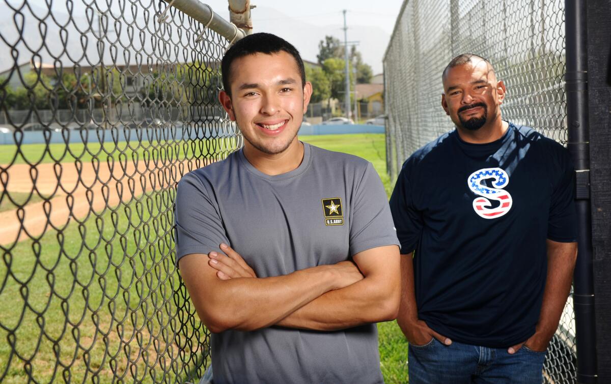 Sylmar High School baseball player Mario Cruz and head coach Ray Rivera stand in the dugout. Cruz along with two other players joined the army and will be leaving for boot camp soon.