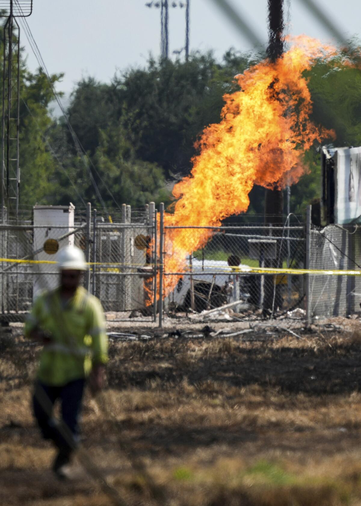 An aboveground valve continues to burn three days after a vehicle drove through a fence and struck the site.