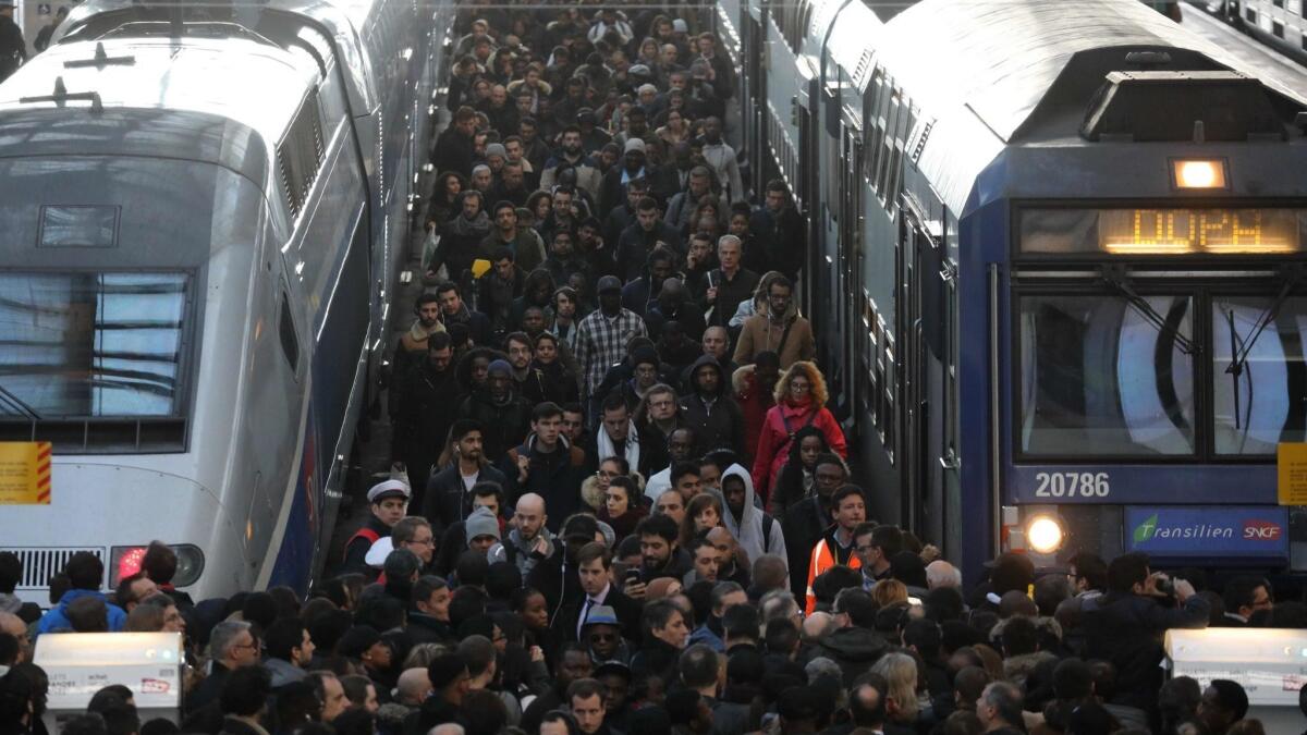 Commuters stand on a crowded platform of the Gare de Lyon railway station in Paris on Tuesday, the first day of a two-day strike.