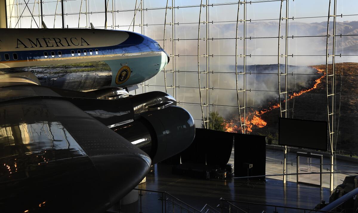 Air Force One on display at the Reagan Library as a helicopter prepares to make a water drop on the Easy Fire in Simi Valley Wednesday.