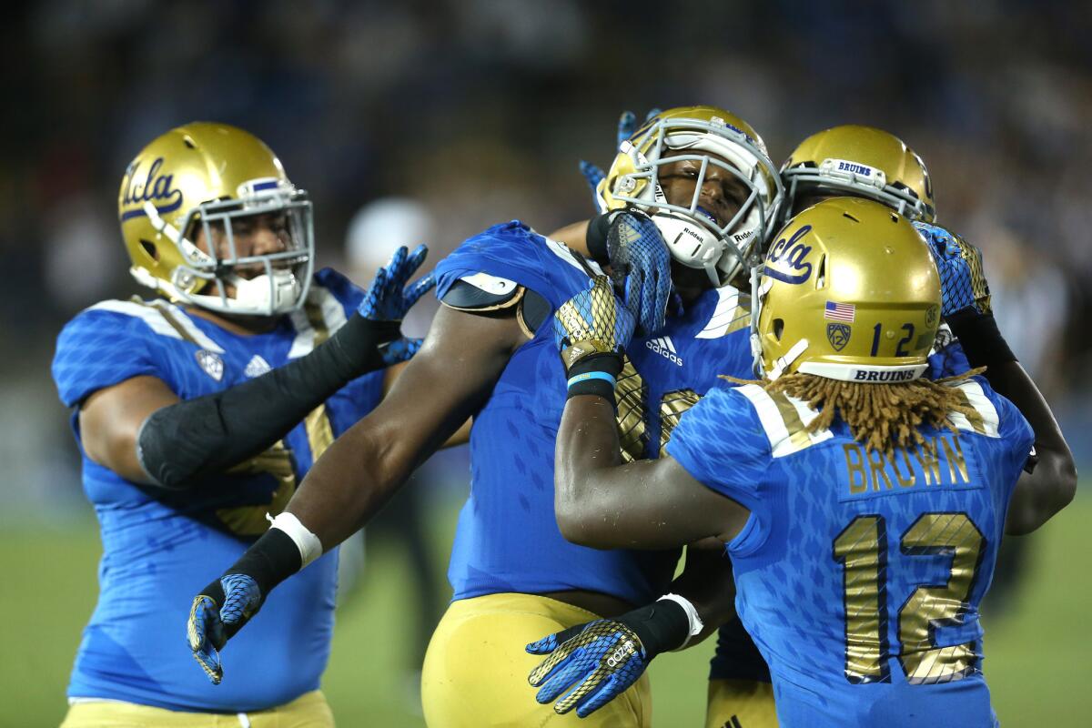 UCLA linebacker Myles Jack is mobbed by Jayon Brown (12) and Jacob Tuioti-Marniner (91) after his fourth-down interception against BYU on Sept. 19.