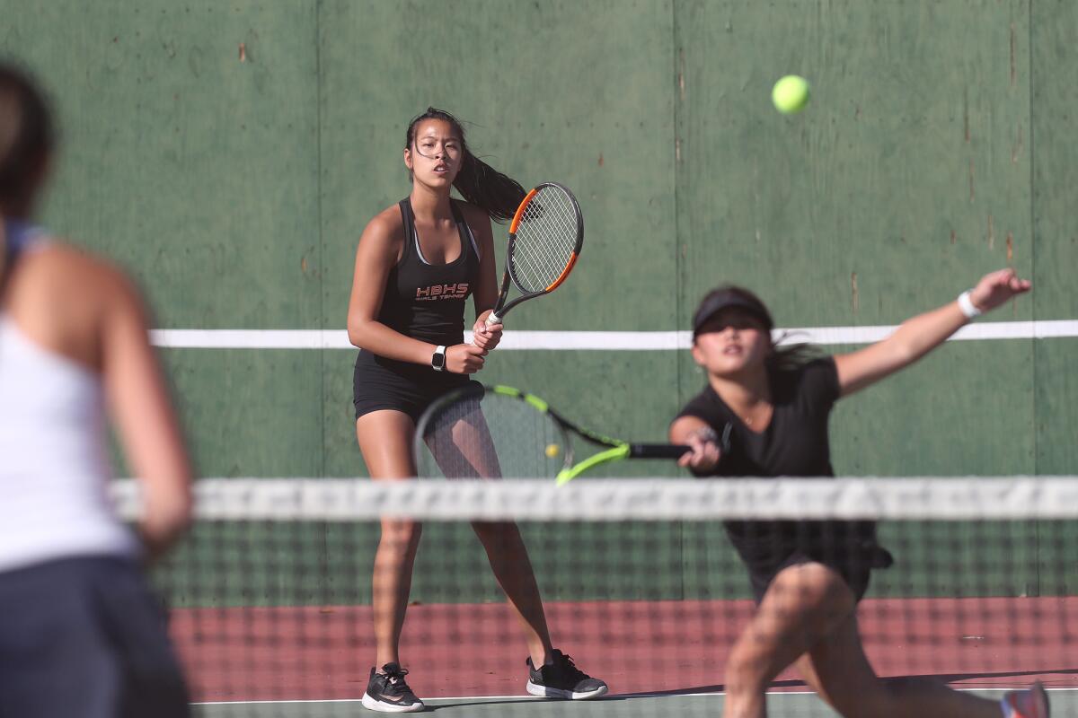 Huntington Beach No. 1 doubles partners Cindy Huynh, center, and Sophie Jin-Ngo, right, compete against Corona del Mar.