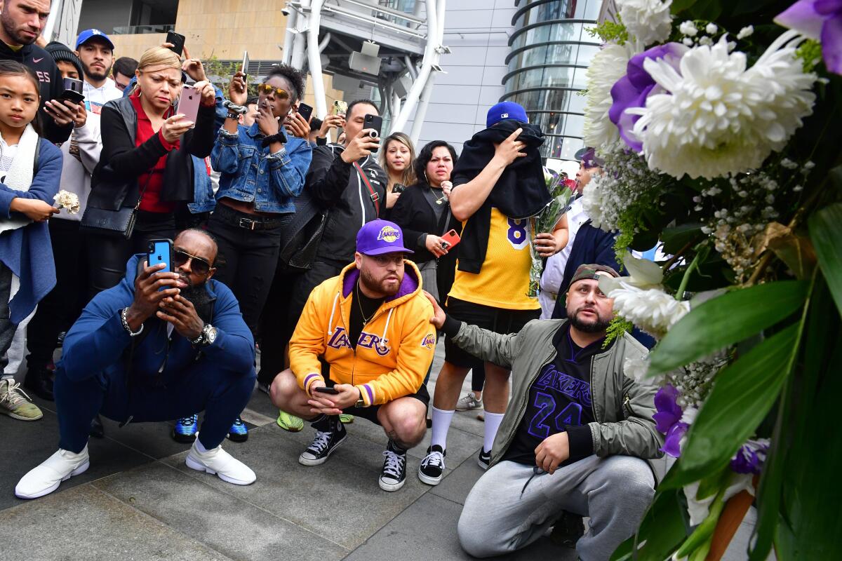 People gather at a memorial for Lakers great Kobe Bryant at L.A. Live, across the street from Staples Center in Los Angeles, the home of the Lakers and, on Sunday, of the Grammy Awards.