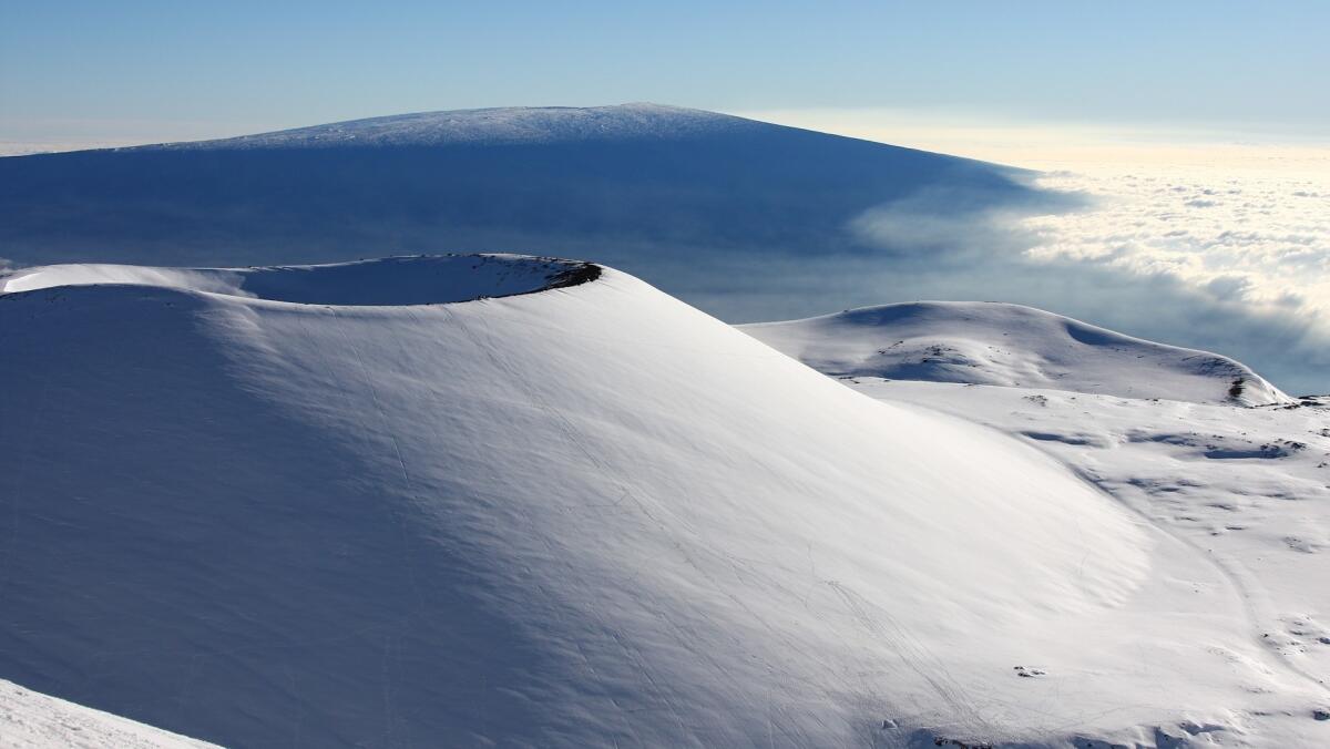 A cinder cone is shrouded in snow following a winter storm atop Hawaii Island's Mauna Kea volcano.