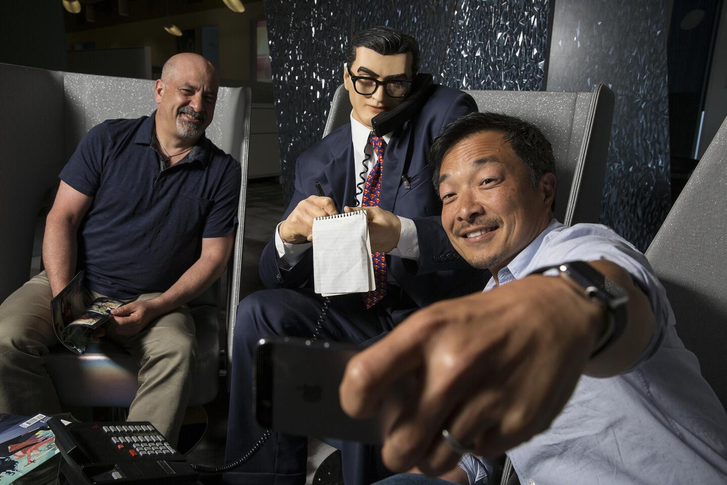 DC Entertainment publishers Dan Didio, left, and Jim Lee take more selfies with Clark Kent at the company headquarters in Burbank.