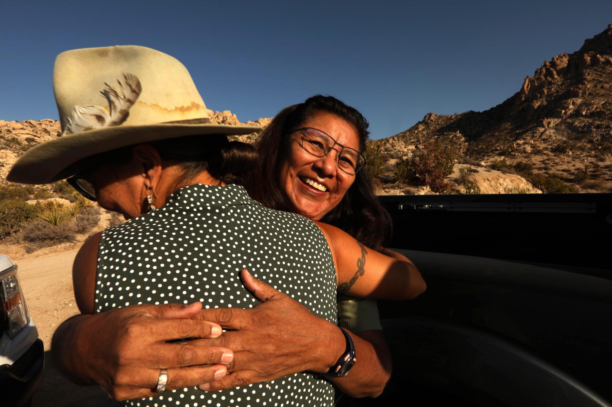 Kim Garrison Means, left, an artist who operates the Mystery Ranch, hugs Linda Otero