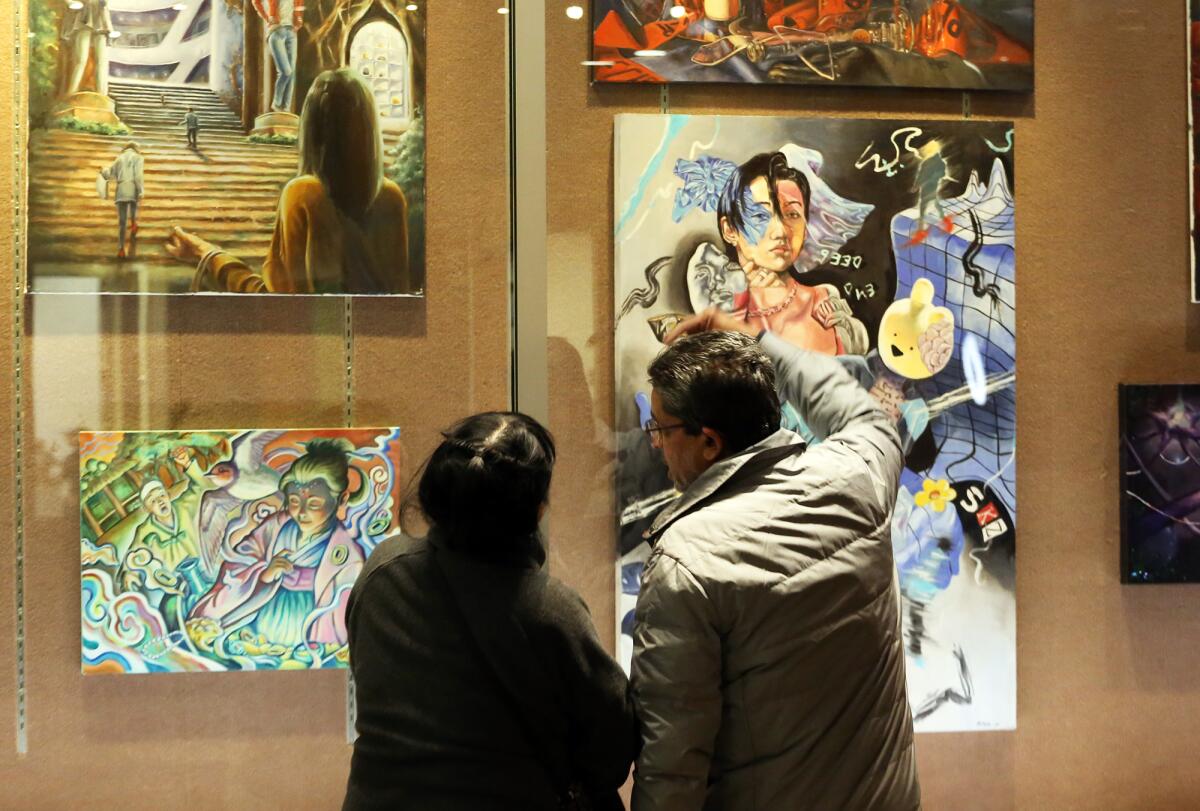 Guests browse through the exhibition "Moments of Youth" organized by the Assn. of Designers and Artists.