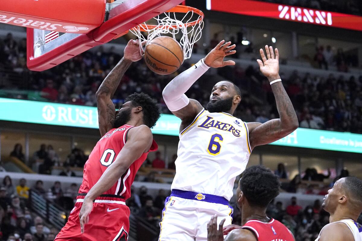 Chicago Bulls guard Coby White dunks past LeBron James during the second half.