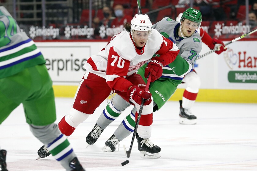 Detroit Red Wings' Troy Stecher (70) drives the puck after taking it away from Carolina Hurricanes' Steven Lorentz (78) during the first period of an NHL hockey game in Raleigh, N.C., Saturday, April 10, 2021. (AP Photo/Karl B DeBlaker)