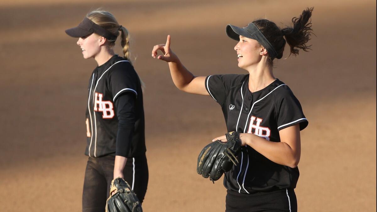 Huntington Beach High's Allee Bunker, left, and Kelli Kufta, right, take the field during the Orange County Softball Coaches All-Star Classic at Bill Barber Park in Irvine on June 5.