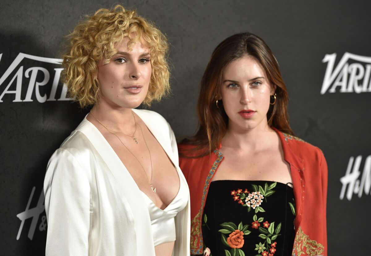 Two women pose on a red carpet