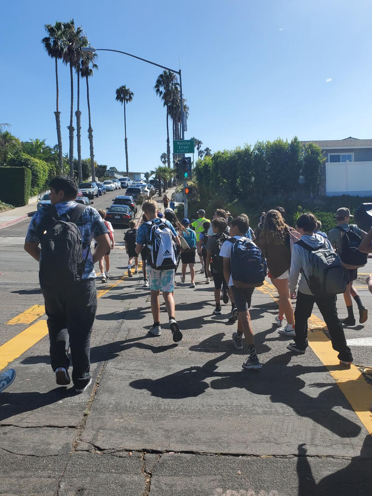 Students cross Nautilus Street at the end of a school day.