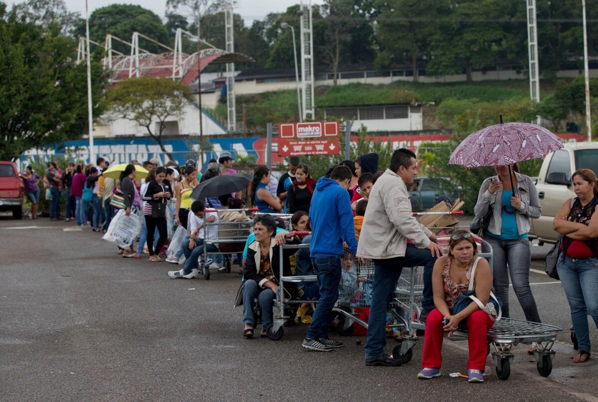 Venezuelans line up outside a supermarket in San Cristobal this week as the country faces a combination of shortages and spiraling inflation.