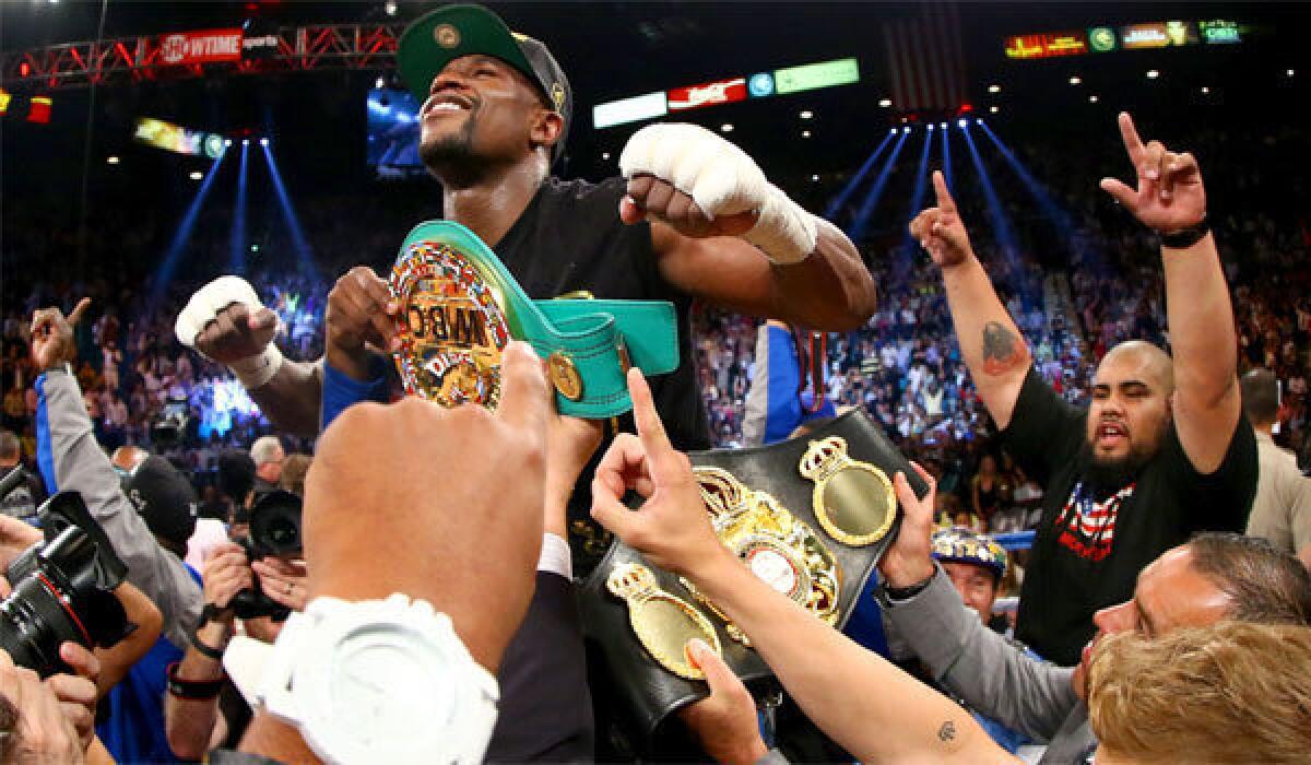 Floyd Mayweather Jr. celebrates his majority decision victory over Saul "Canelo" Alvarez in their WBC/WBA 154-pound title fight Saturday night at the MGM Grand Garden Arena in Las Vegas.