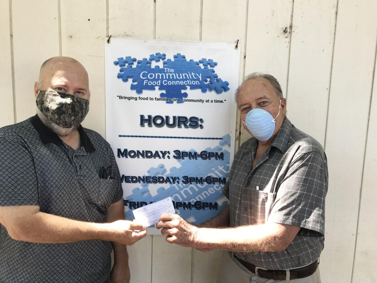 The Community Food Connection's Bill Rearick receiving the check from Patrick Korch.