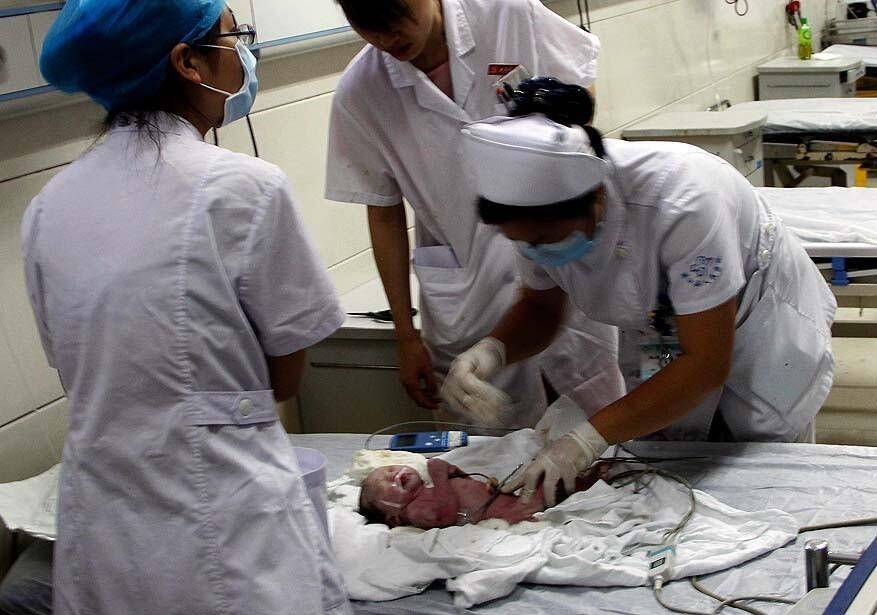 Medical personnel take care of the five-pound baby who was stuck in a toilet pipe for two to three hours at the Pujiang People's Hospital on Wednesday. Local officials said the boy is healthy.