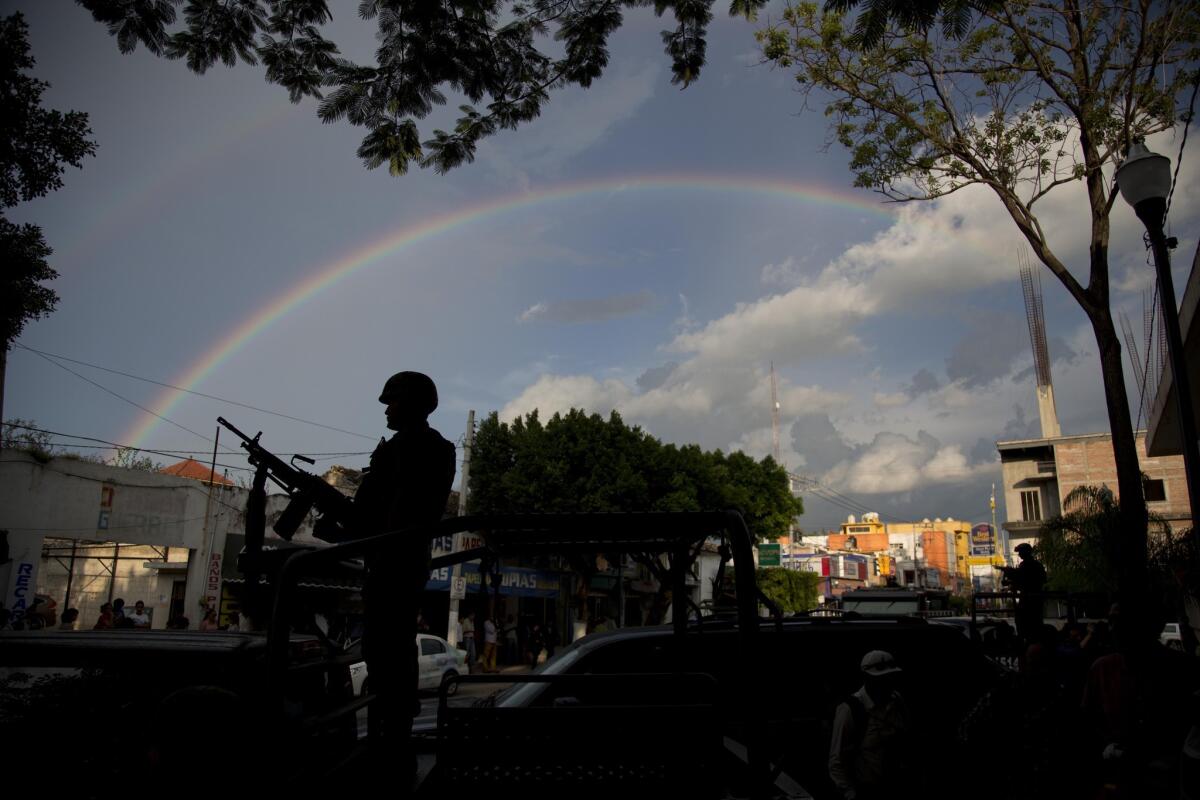 A rainbow forms a backdrop for a soldier standing guard in Iguala, in Mexico's Guerrero state, on Oct. 6.