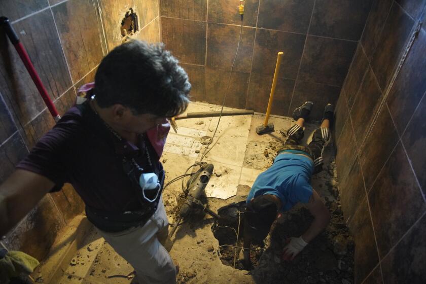 TIJUANA, BAJA CALIFORNIA - SEPTEMBER 22: Parents and family members who have formed collectives throughout Mexico to help each other search for the remains of their missing children. Volunteers take turns digging through the debris under a stash house. Alfredo Ruiz 6, looks over Esteban 17, brother of missing Csar Ezequiel Rico de la Cerda as he removed dirt from where they recently dig at Colonia Campos on Tuesday, Sept. 22, 2020 in Tijuana, Baja California. (Alejandro Tamayo / The San Diego Union-Tribune)