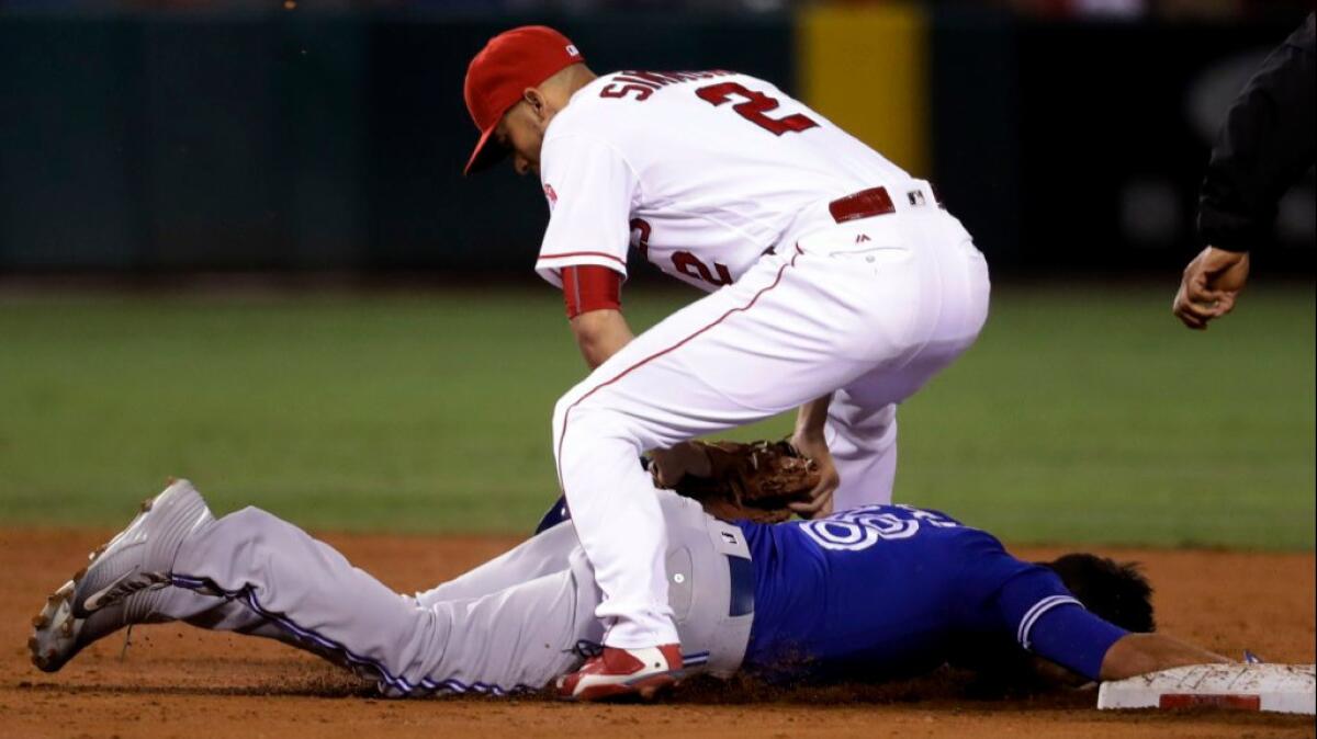 Angels shortstop Andrelton Simmons tags out Blue Jays infielder Darwin Barney as he dives back toward second base during the third inning of a game on Sept. 16.