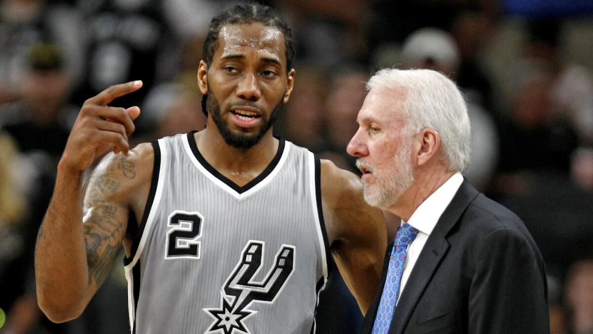 Spurs forward Kawhi Leonard talks to coach Gregg Popovich during a game last season in San Antonio.