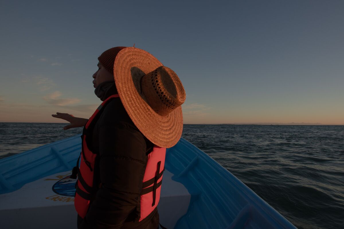 A guy on a boat with a sunhat.