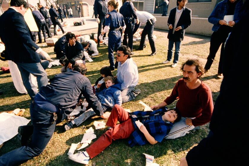 Injured children are attended to in a schoolyard of the Cleveland elementary school in Stockton, Calif., Jan. 17, 1989, after a heavily armed gunman in combat fatigues opened fire killing five children and injuring 30 others, authorities said. (AP Photo/Stockton Record)