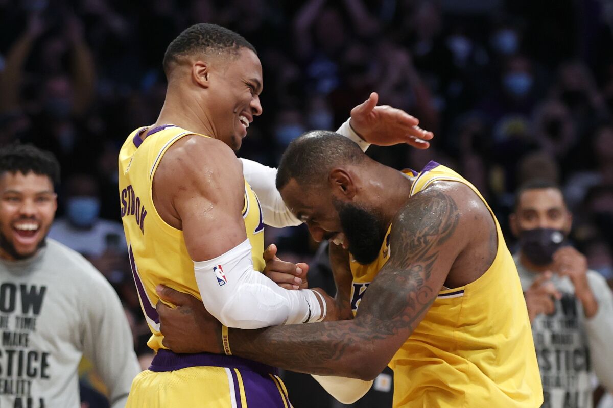 Lakers guard Russell Westbrook is congratulated by teammate LeBron James after scoring against the Jazz on Monday.