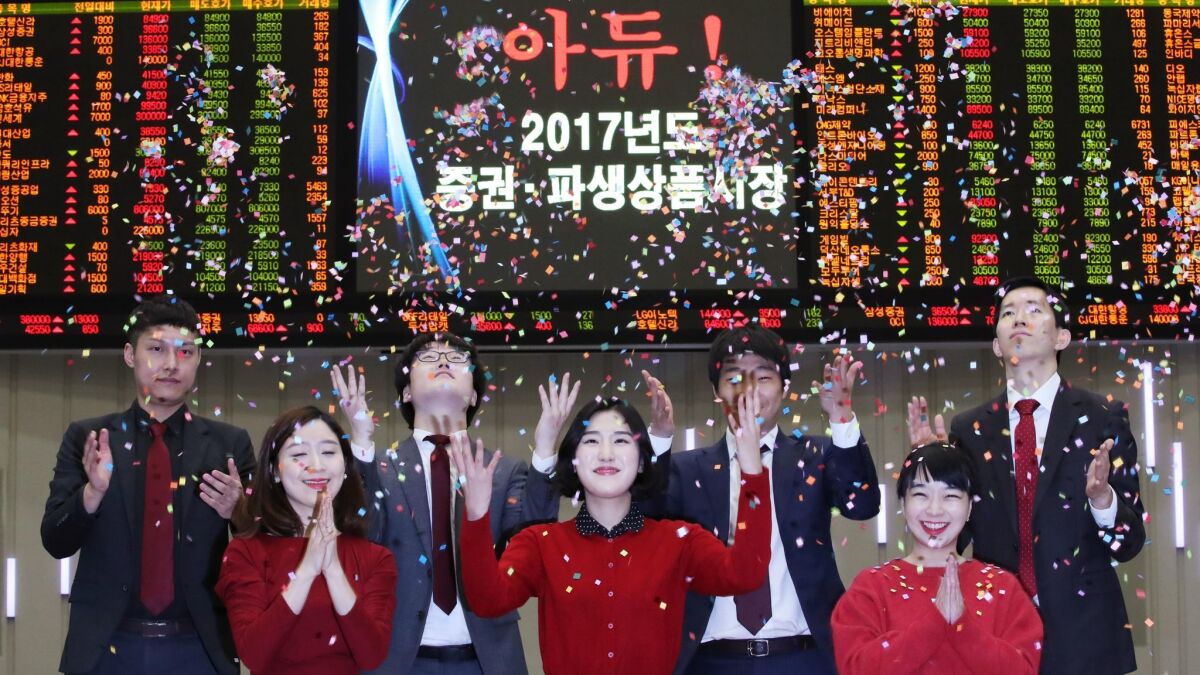 Employees applaud during a ceremony to close this year's market trading at the Korea Exchange in Seoul.