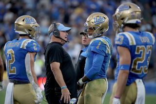 PASADENA, CALIF. - OCT. 23, 2021. UCLA head coach Chip Kelly talks with quarterback Dorian Thompson-Robinson.