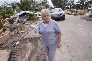 Elsie Hicks looks at the destruction of the home she has loved in for 25 years, in the aftermath of Hurricane Helene, in Horseshoe Beach, Fla., Saturday, Sept. 28, 2024. (AP Photo/Gerald Herbert)