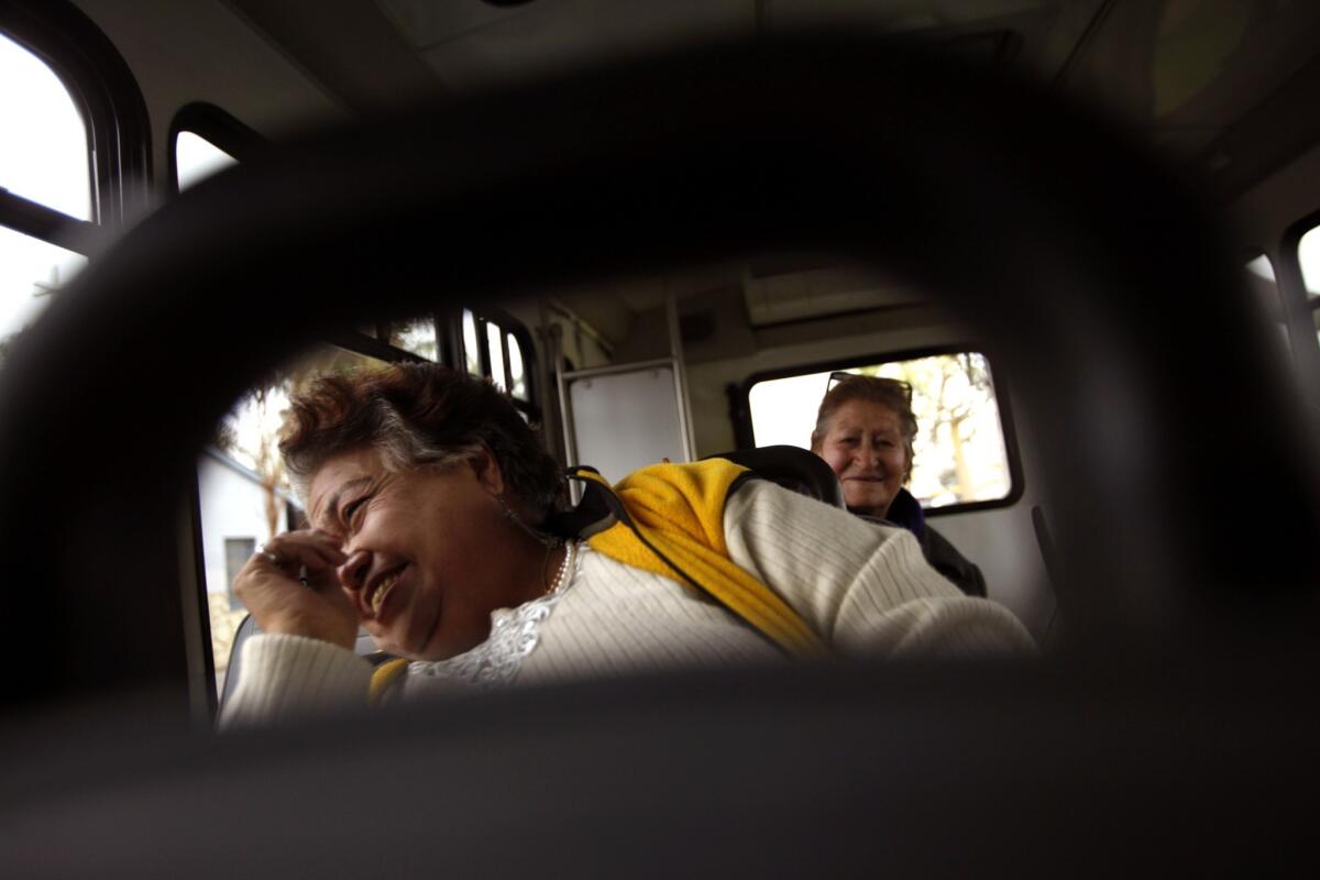 Salud Suarez, 65, left, and Maria Ruiz, 87, share a laugh on the Dial-A-Ride bus. The amigas open up about everything: their husbands and their families, their aches and their regrets.