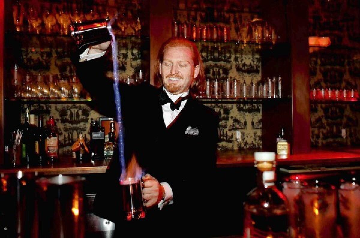 Daniel K. Nelson, who will be the head bartender for The Writer's Room, mixes a Blue Blazer drink, which will be one of the drinks on the menu when the bar opens on Friday.