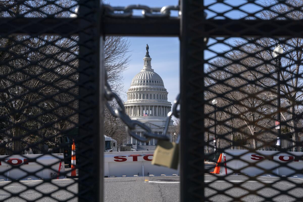 The U.S. Capitol is seen through a locked gate.