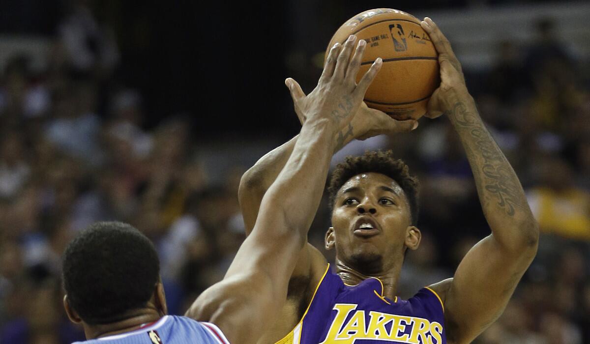 Los Angeles Lakers forward Nick Young, right, shoots over Sacramento Kings forward Rudy Gay during the second half on Oct. 30.
