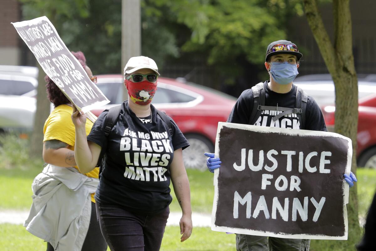 People wearing Black Lives Matter T-shirts protest.