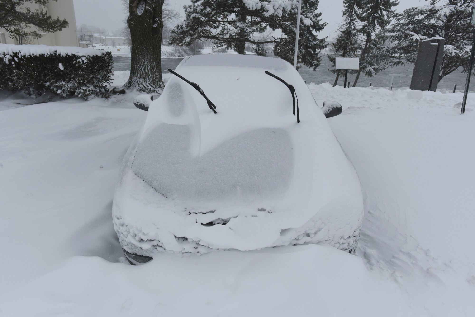 A car remains buried under several inches of snow at the Margaret B. Upton Arboretum in St. Joseph, Mich.