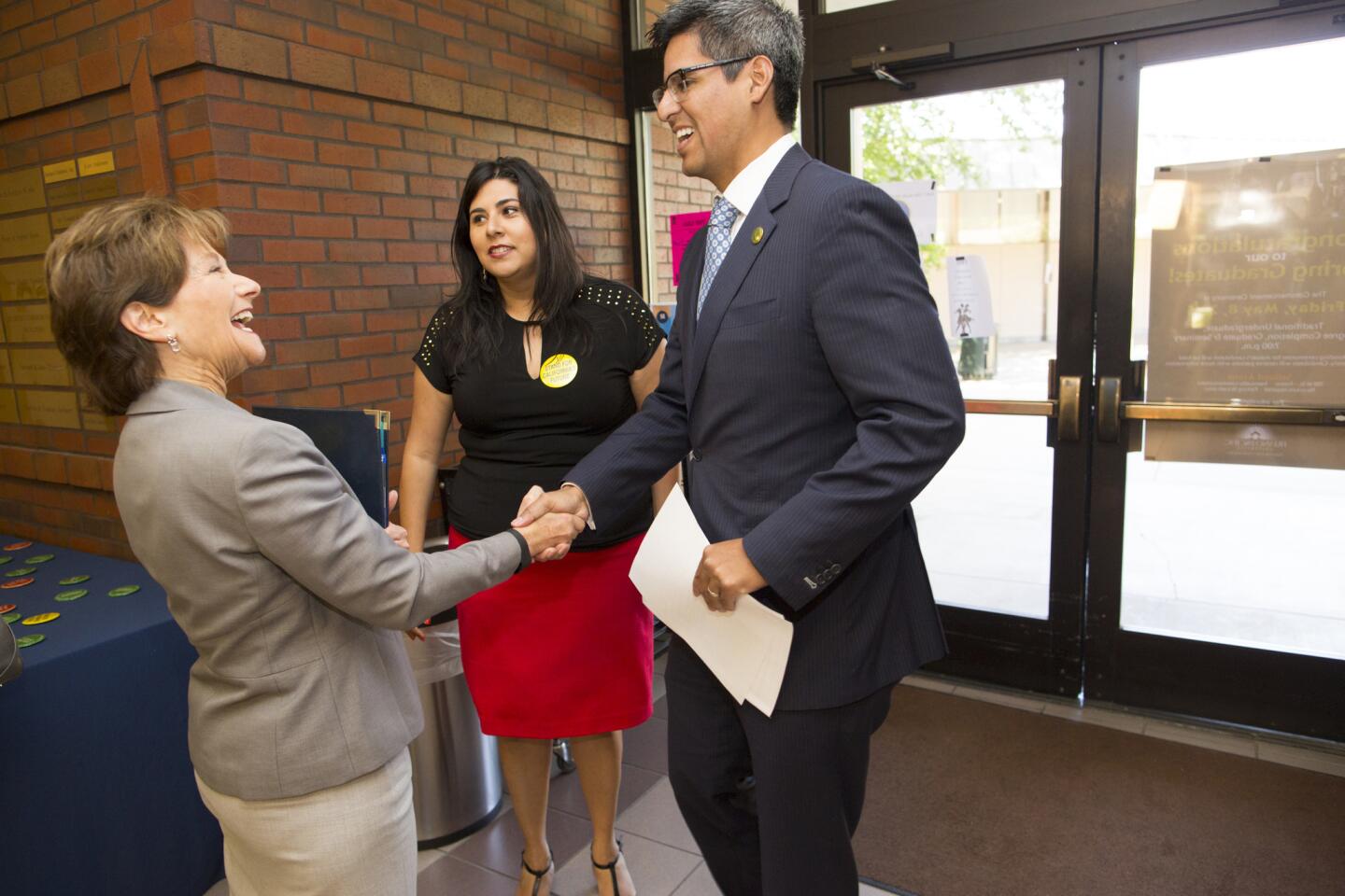 Assemblyman Henry Perea is greeted by Fresno Pacific University's vice president of communications, Diana Mock, as Yammilette Rodriguez looks on before a news conference protesting proposed cuts to the Cal Grant program for incoming students at private schools.