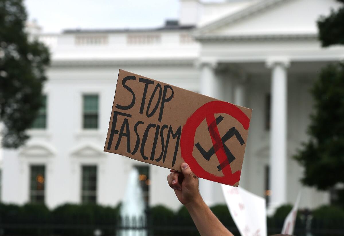 A man holds up a sign during a protest in front of the White House on Aug. 14.