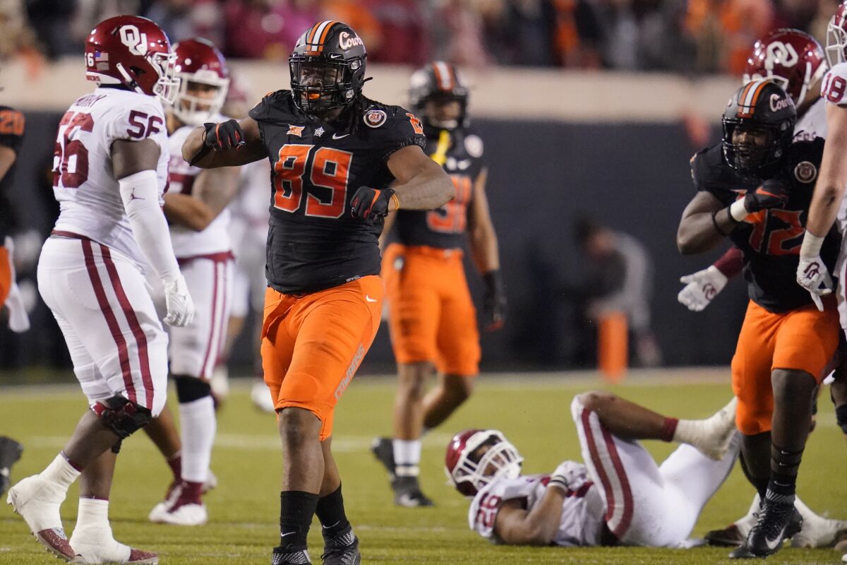 Oklahoma State defensive end Tyler Lacy (89) celebrates a tackle Nov. 27, 2021.