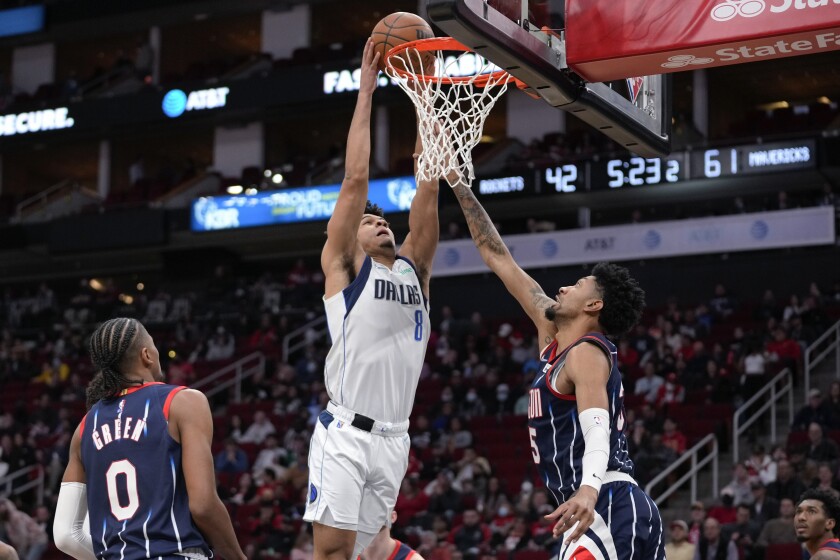 Dallas Mavericks guard Josh Green (8) dunks as Houston Rockets center Christian Wood, right, defends during the first half of an NBA basketball game Friday, Jan. 7, 2022, in Houston. (AP Photo/Eric Christian Smith)