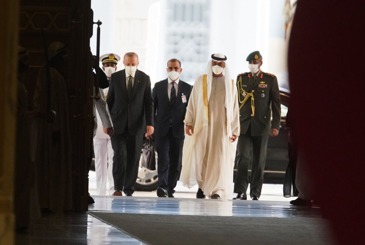 Turkish President Recep Tayyip Erdogan, left, and Abu Dhabi Crown Prince Sheikh Mohammed bin Zayed Al Nahyan, second right, arrive at Qasr Al-Watan in Abu Dhabi, United Arab Emirates, Monday, Feb. 14, 2022. Erdogan traveled Monday to the United Arab Emirates, a trip signaling a further thaw in relations strained over the two nations' approaches to Islamists in the wake of the 2011 Arab Spring. (AP Photo/Jon Gambrell)