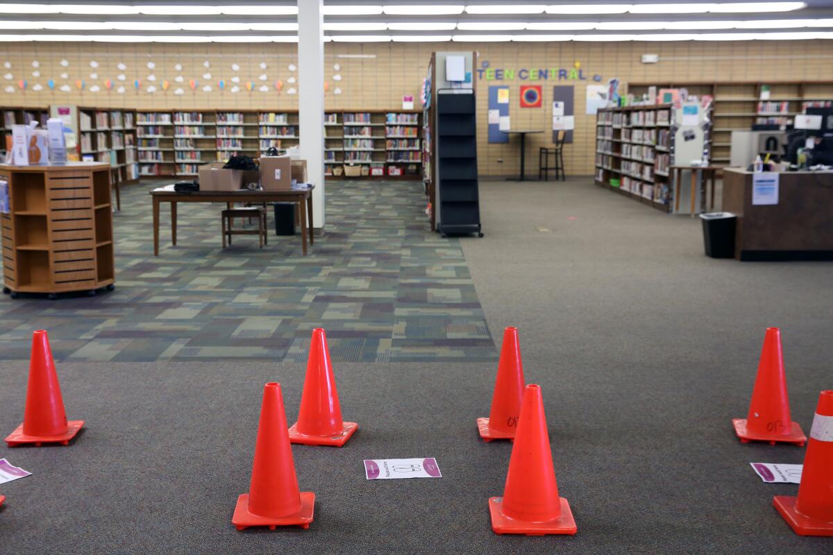 Orange cones are spread out inside a library