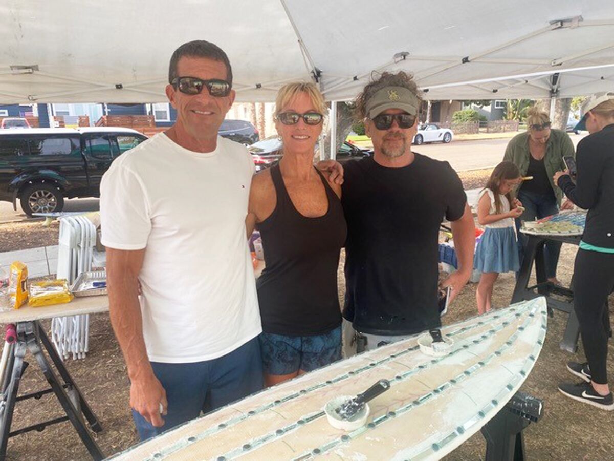 Brian J. Curry, his wife Shari Simpson and artist Rob Tobin working on the refurbished surfboards for the PB Rec Center.