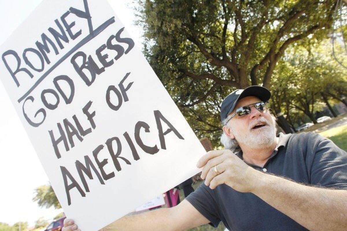 Mickey Corsi of Bedford, Texas, shows his response to Mitt Romney's controversial remarks as he demonstrates outside a Romney fundraising event in Dallas.