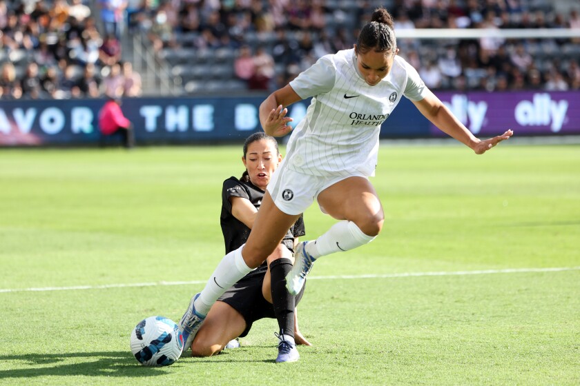 Angel City's Christen Press slide tackles Orlando's Darian Jenkins during the first half of Angel City's 1-0 loss Sunday.