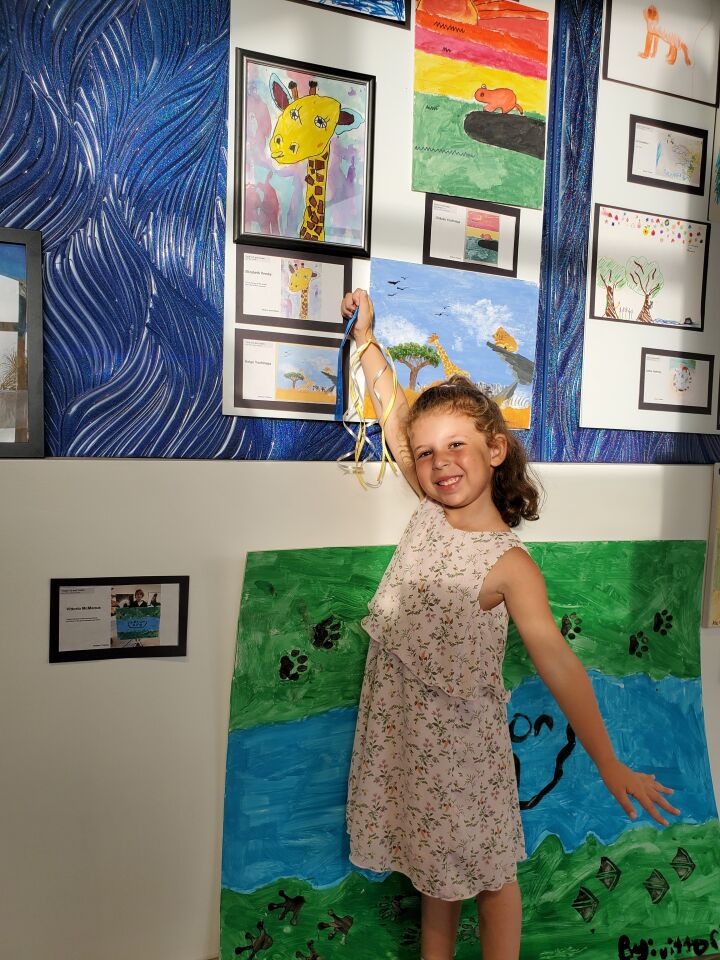 Elizabeth Versky, second-place winner and fan favorite in the youth category, points to her giraffe drawing.