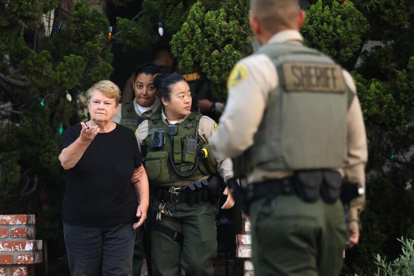 SANTA MONICA, CA - SEPTEMBER 10, 2022 - - Los Angeles County sheriffs escort Los Angeles Supervisor Shelia Kuehl's from her house after serving her an early morning search warrant in Santa Monica on September 10, 2022. This was part of a criminal investigation into a county contract awarded to a nonprofit organization. Sheriff's investigators also searched Patti Giggans' house, her nonprofit's offices, officers at the L.A. County Hall of Administration and the headquarters of the county's Metropolitan Transportation Authority, which awarded a contract to Giggans' Peace Over Violence." (Genaro Molina / Los Angeles Times)