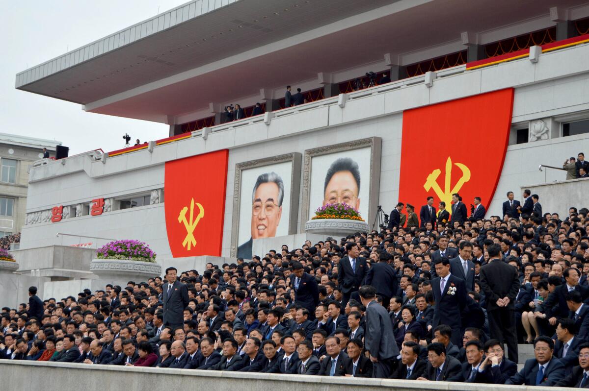 North Koreans watch Tuesday's parade in Pyongyang that featured military-themed floats and an appearance by leader Kim Jong Un.
