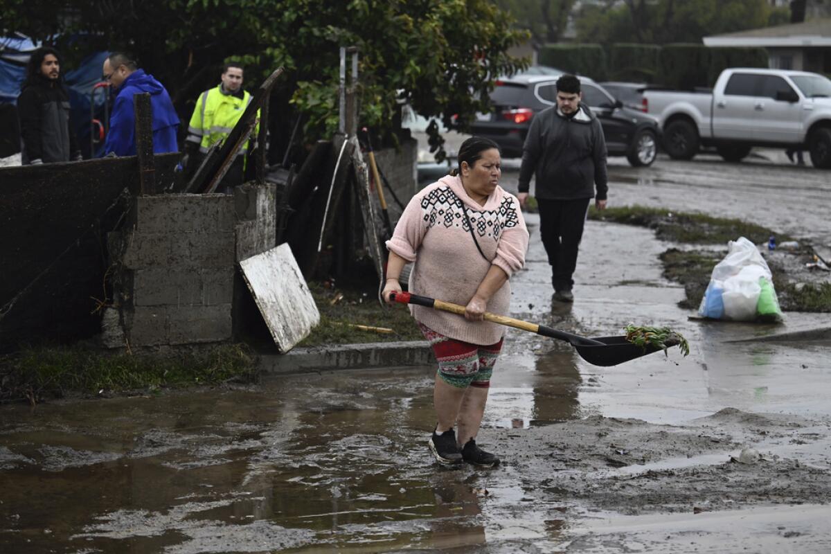 Una mujer retira escombros de las inundaciones 